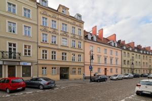 una hilera de edificios con coches aparcados delante de ellos en Best Location Old Town, en Poznan