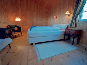ein Schlafzimmer mit einem Bett und einem Tisch in einem Zimmer in der Unterkunft Seaside View Lofoten in Bøstad