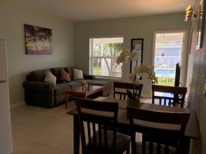 uma sala de estar com uma mesa e um sofá em Coral Key Inn em Fort Lauderdale