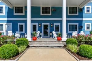 una casa blu con colonne e fiori bianchi di Commander Beach House Hotel a Ocean City