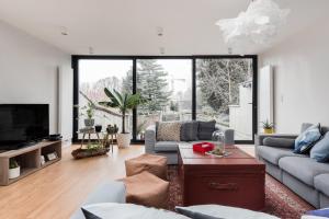 a living room with couches and a large window at Flemishome, The Retreat For Family And Friends in Halle