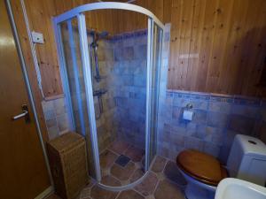 a bathroom with a shower with a wooden toilet at Seaside View Lofoten in Bøstad