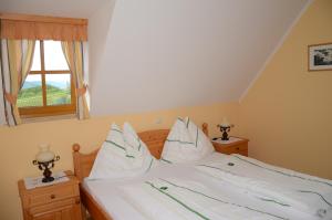 um quarto com uma cama com lençóis brancos e uma janela em Weingut Fellner em Leutschach