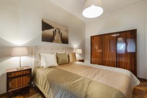 1 dormitorio con 1 cama grande y cabecero de madera en Sea & Relax Villa Nazaré, en Nazaré
