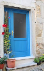 a blue door on a stone building with flowers at Fenix in Motovun