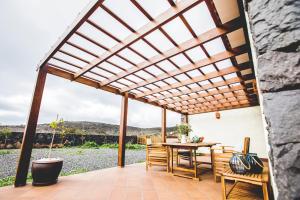 a pergola on a patio with a table and chairs at La Casita de Papel in Valle Gran Rey