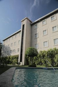 a building with a swimming pool in front of it at Hotel Gardenia Inn in San Salvador