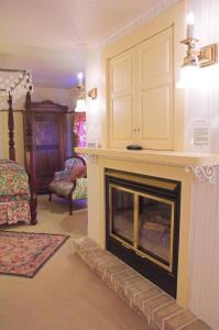 a living room with a fireplace and a bed at White Lace Inn in Sturgeon Bay