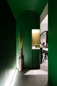 ein grüner Raum mit einer Vase mit einer Pflanze darin in der Unterkunft Etruscan Luxury Suites in Rom + 15 Fotos