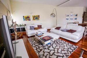 Sala de estar con 2 sofás blancos y mesa de centro en Villa Casalinho Meco en Aldeia do Meco