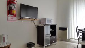 TV de pantalla plana en la parte superior de un armario en Departamento de 1 Dormitorio con Sala Estar en Río Grande