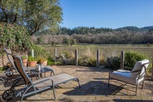 a patio with a table and chairs and a field at Wine Country Inn Napa Valley in St. Helena
