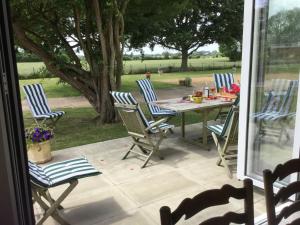 une terrasse couverte avec une table et des chaises. dans l'établissement Eight ball house, à Southburgh