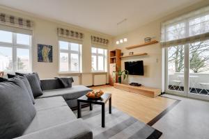 a living room with a couch and a tv at Lion Apartments - Parkowa 41m4 plaża 2 min in Sopot