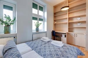 a bedroom with a bed and a desk and windows at Lion Apartments - Parkowa 41m4 plaża 2 min in Sopot