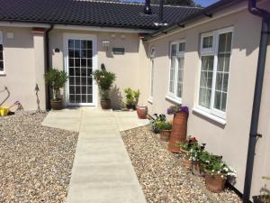 a house with potted plants and a walkway at Eight ball house in Southburgh