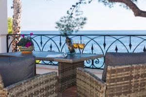 una mesa y sillas en un balcón con vistas al océano en Villa Mallandrino, en Mondello