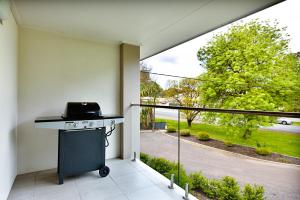 uma varanda com um grelhador e vista para um quintal em Apex Park Holiday Apartments em Wangaratta