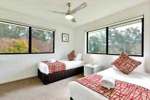 1 dormitorio con 2 camas y 2 ventanas en Apex Park Holiday Apartments, en Wangaratta