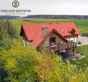 uma vista aérea de uma casa com um telhado vermelho em Dom nad Krzywym - prywatna plaża, 2 boiska, sauna, plac zabaw em Krzywe