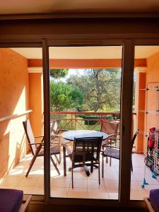 een terras met een tafel en stoelen op een balkon bij Ecrins de la Badine- pinède in Hyères