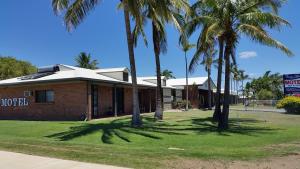 a brick building with palm trees in front of it at True Blue Motor Inn in Rockhampton