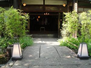 a walkway with two lights in front of a building at Kurhaus Ishibashi Ryokan in Shimoda