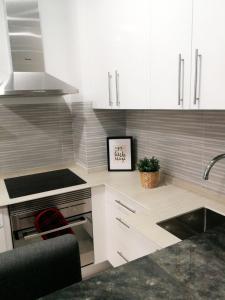 a kitchen with white cabinets and a sink at Your comfy stay in the Center of Madrid in Madrid