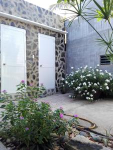 a stone house with two doors and flowers at The House 17/1 in Mui Ne