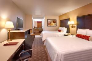 a hotel room with two beds and a television at Cortona Inn and Suites Anaheim Resort in Anaheim
