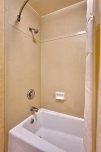 a bathroom with a white tub and a sink at Cortona Inn and Suites Anaheim Resort in Anaheim