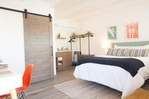 a bedroom with a bed and a sliding barn door at Surfhouse in Encinitas