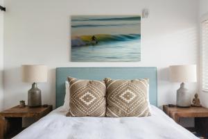 ein Schlafzimmer mit einem Bett mit zwei Lampen und einem Gemälde in der Unterkunft Surfhouse in Encinitas