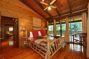 a bedroom with a bed in a room with wooden walls at Wait-a-While Eco Retreat in Cow Bay