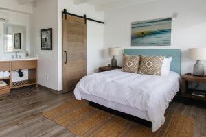 a bedroom with a bed and a bathroom with a sink at Surfhouse in Encinitas