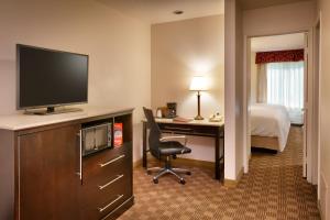 a hotel room with a desk with a television and a bed at Cortona Inn and Suites Anaheim Resort in Anaheim +25 photos