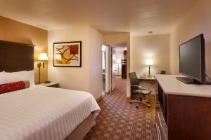 a hotel room with a bed and a flat screen tv at Cortona Inn and Suites Anaheim Resort in Anaheim