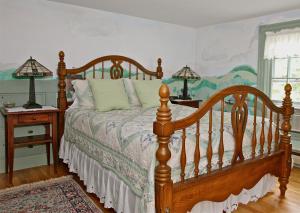 um quarto com uma cama de madeira e 2 candeeiros em Maguire House Bed and Breakfast em Ashburnham