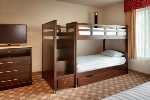 a room with two bunk beds and a television at Cortona Inn and Suites Anaheim Resort in Anaheim