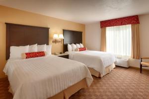 a hotel room with two beds and a window at Cortona Inn and Suites Anaheim Resort in Anaheim
