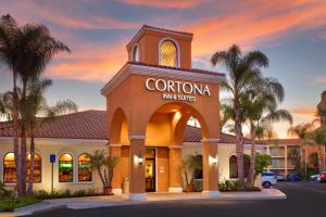 a corona inn and suites building with palm trees at Cortona Inn and Suites Anaheim Resort in Anaheim