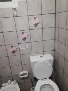 Baño pequeño con aseo y azulejos rosados en Alquileres Vimar en Las Grutas