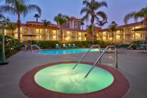 a hotel with a swimming pool and a resort at Cortona Inn and Suites Anaheim Resort in Anaheim