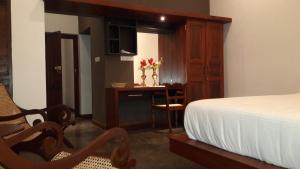 a bedroom with a bed and a desk and a table at Villa 35F in Galle