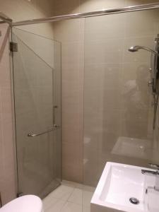 a bathroom with a glass shower and a sink at The V Hotel in Kuantan