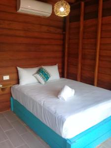 1 cama con sábanas blancas y almohadas en una habitación en Hotelito Villas Holbox en Holbox Island