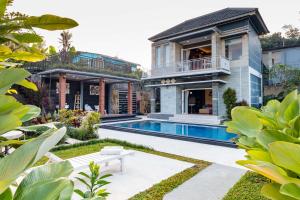 an exterior view of a house with a swimming pool at Villa Cetta in Ubud