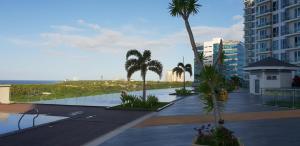 Blick auf ein Resort mit Palmen und einem Gebäude in der Unterkunft Apartment Sea View at Mactan Newtown in Mactan