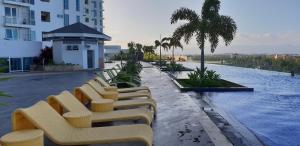 a row of chairs sitting next to a pool on a building at Apartment Sea View at Mactan Newtown in Mactan