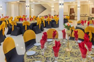 - une salle de banquet avec des tables, des chaises et des serviettes rouges dans l'établissement Sense Pavillion, à Horana